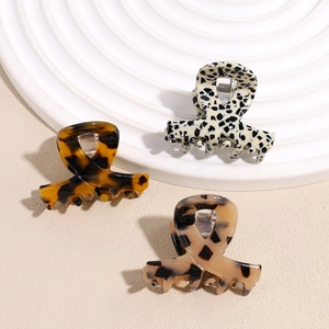 Three-piece acetate claw clip set with tortoiseshell and spotted patterns on white tray