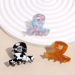 Crossed acetate hair claw clips in floral, cow print, and amber patterns for women