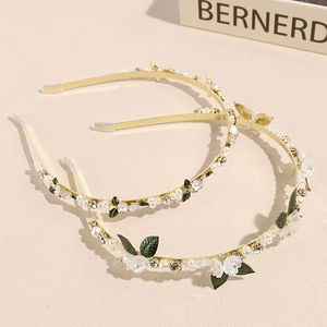 Serre-têtes fleurs dorés élégants avec perles, feuilles vertes et strass sur fond beige
