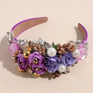 Close-up of handmade baroque headband with purple fabric roses, pearls and crystals