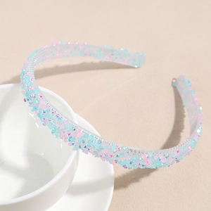 Détail de strass colorés étincelants sur un serre-tête élégant posé sur une tasse
