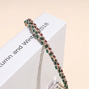 Elegant crystal headband with red and green rhinestones in a woven golden metal frame