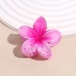 Close-up of a gradient pink flower hair claw clip with shimmering glitter finish