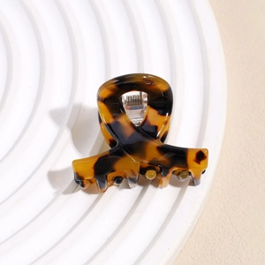 Detailed close-up of a mini acetate claw clip with a classic tortoiseshell pattern finish