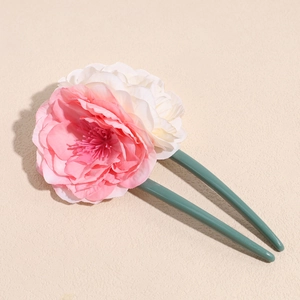 Detailed view of U-shaped hair pin featuring pink and white fabric rose flowers