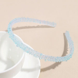 Détail d'un serre-tête bleu clair en gelée avec des strass colorés sur une tasse blanche