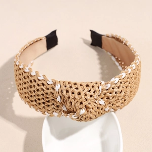 Detail of cross-knot raffia headband with woven texture in beige and white finish