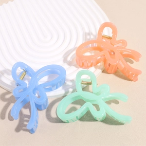 Three jelly-colored butterfly hair claws in pastel blue, coral pink and mint green