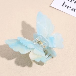 Macro detail of a 3D light blue butterfly hair claw clip with a shimmering glitter finish