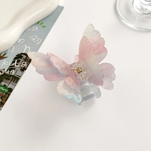 Detail of a 3D butterfly hair claw with purple gradient glitter and gold spring mechanism