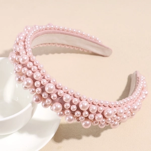 Detailed view of handmade pink baroque sponge headband with faux pearls on fabric
