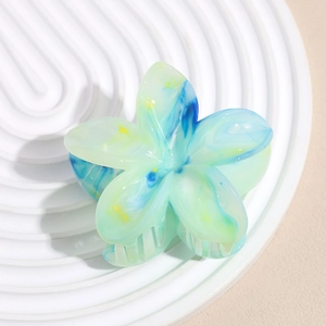 Detailed view of 6cm flower hair claw with gradient marble texture on white tray