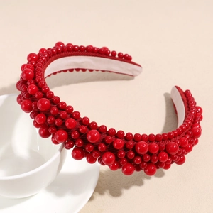 Detail view of red Baroque headband with mixed size beads on a white coffee cup