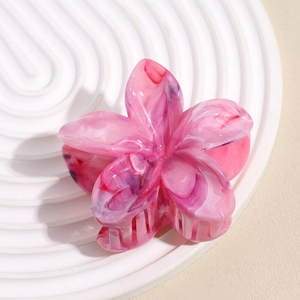 Detail of flower hair claw clip with pink marble texture on a white display stand