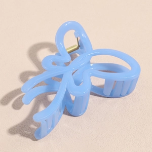 Detailed macro view of a large translucent blue butterfly hair claw clip with gold spring