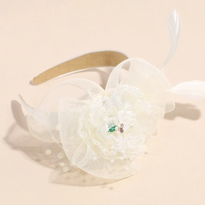 Close-up of white mesh flower headpiece with feathers and pearls for wedding parties