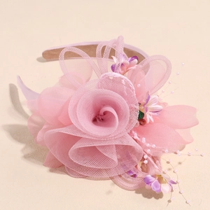 Détail du serre-tête fleur en résille rose avec perles et ruban de satin doux