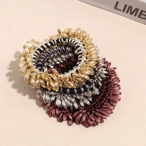 Close-up of wheat ear metallic hair ties in gold silver and bronze colors
