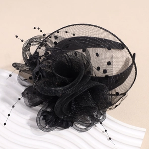 Détail d'un fascinateur noir rétro avec voile en résille à pois et grande fleur en tulle