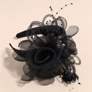 Détail d'un serre-tête en résille noire avec fleur de rose et perles délicates