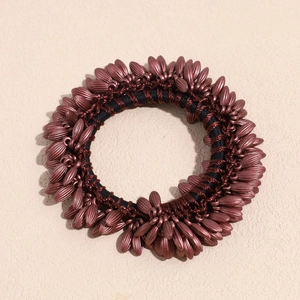 Detailed macro view of woven copper bead hair tie with high elastic black rubber band