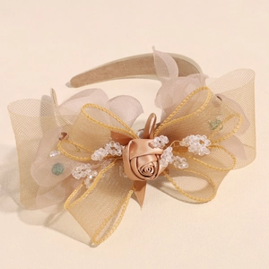 Detailed view of champagne mesh bow headband with satin rose and crystal beads
