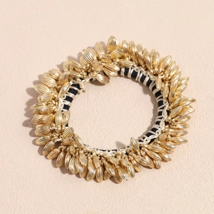 Detailed view of elastic hair tie featuring golden metallic wheat-shaped striped ornaments