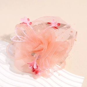 Détail d'un bibi floral rose élégant avec voile en maille et petites perles de finition