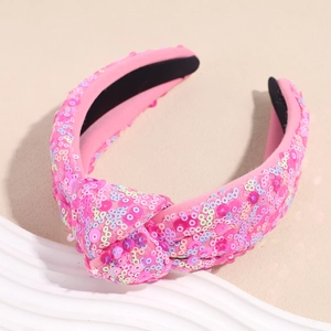 Dettaglio del cerchietto rosa con nodo superiore decorato con paillettes colorate lucide