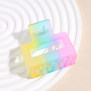 Detail showing gradient rainbow matte hair claw clip on a white decorative plate