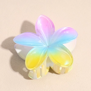 Gros plan d'une pince à cheveux fleur de frangipanier avec dégradé de couleurs