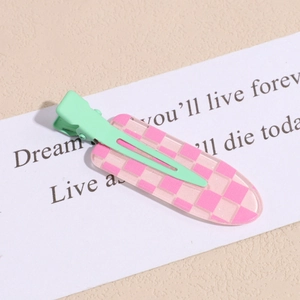 Close-up of pink checkered acrylic duckbill hair clip on a minimalist background