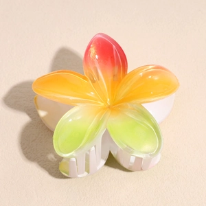 Détail de la pince à cheveux fleur de frangipanier avec dégradé arc-en-ciel et paillettes
