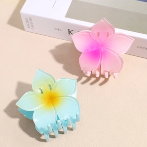 Floral frangipani hair claw clips with pink and yellow gradient colors in a set