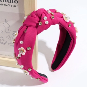 Dettaglio della fascia annodata rosso rosa con perle bianche, cristalli e piccoli fiori