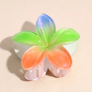 Détail d'une pince à cheveux en acrylique avec fleur à 5 pétales et dégradé nacré brillant