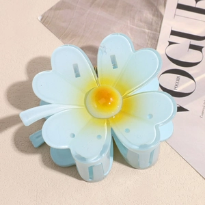 Détail macro de la pince à cheveux en forme de fleur dégradé bleu et jaune avec sa structure