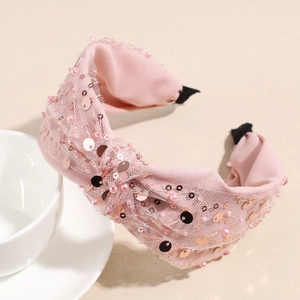 Dettaglio del cerchietto in rete rosa con paillettes e decorazioni di perle finte