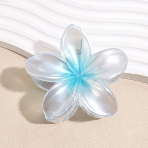 Dettaglio di un fermaglio per capelli a forma di plumeria sfumata blu e bianco in resina