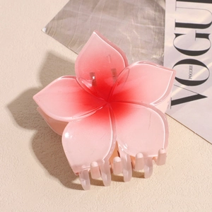 Close-up of a gradient pink plumeria hair claw clip with sturdy resin teeth for buns