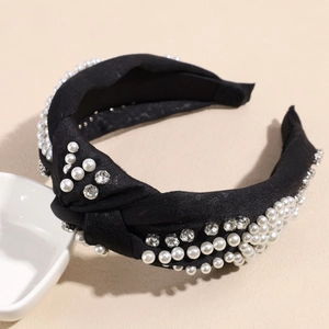 Détail d'un serre-tête noué noir orné de perles élégantes et de strass scintillants