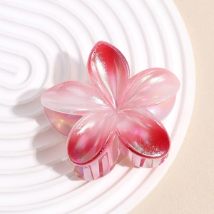 Vue macro d'une grande pince à cheveux fleur nacrée avec dégradé de rose et effet irisant