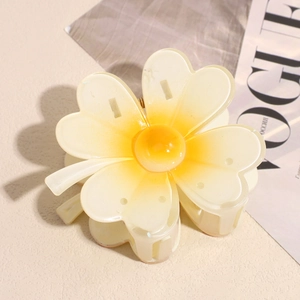 Vue détaillée d'une pince à cheveux en forme de fleur de frangipanier à dégradé jaune et blanc