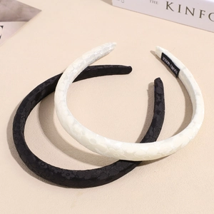 Dettaglio di cerchietti fatti a mano in jacquard floreale nero e crema strutturato
