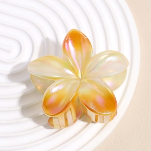 Détail d'une grande pince à cheveux fleur nacrée avec un dégradé de tons orange vif