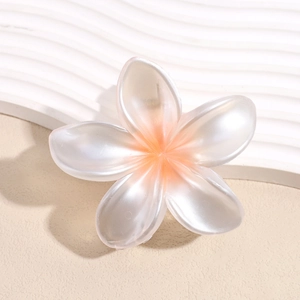 Dettaglio molletta per capelli a fiore di frangipane in resina con sfumatura arancio