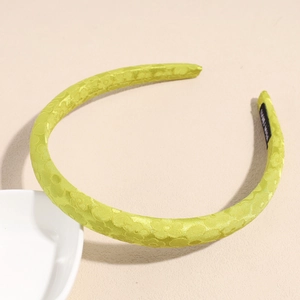 Dettaglio del tessuto jacquard verde limone e della trama a margherite sul cerchietto largo
