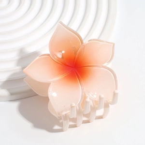 Macro detail of the orange gradient frangipani hair claw clip on white display