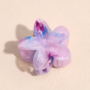 Dettaglio della molletta per capelli in acetato marmorizzato con sfumatura viola e blu