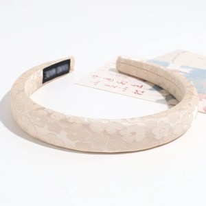Cerchietto largo beige imbottito con trama jacquard floreale ed etichetta fatta a mano